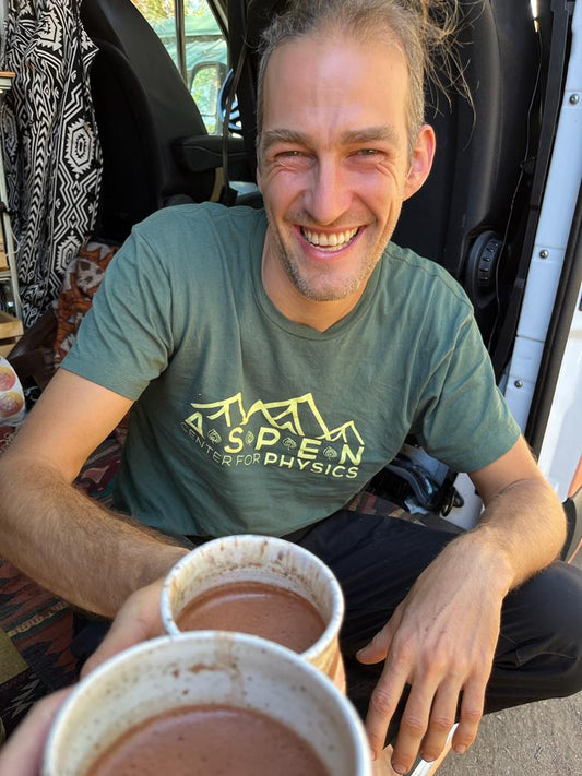 A joyful, uplifting photo showing a cacao toast to health and happiness in a group setting