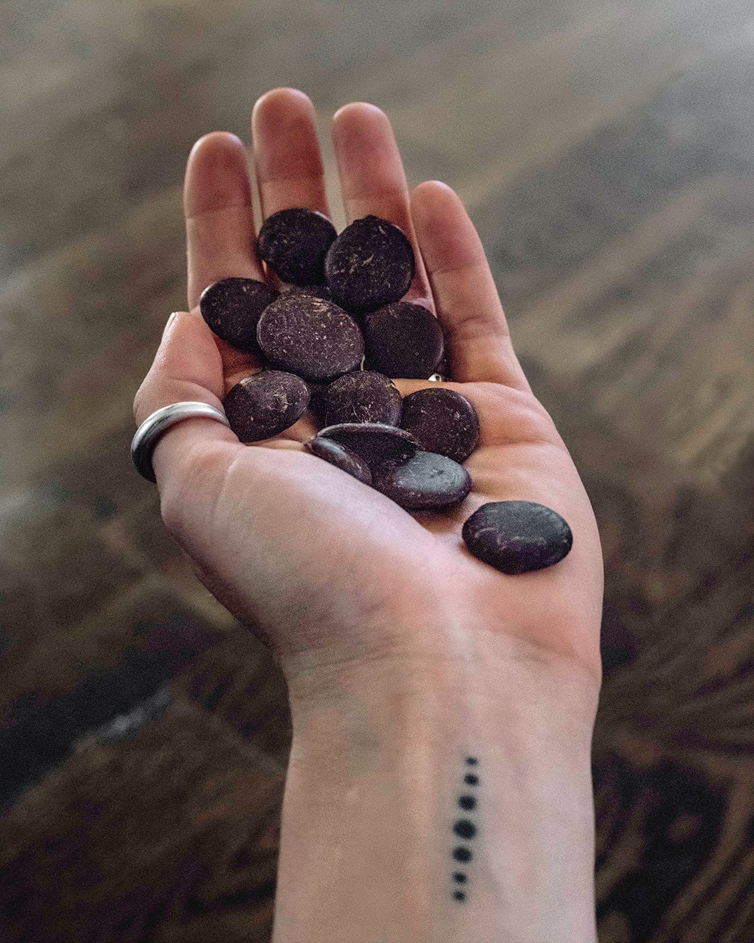 A hand holding cacao discs, showcasing the artisanal quality of the chocolate
